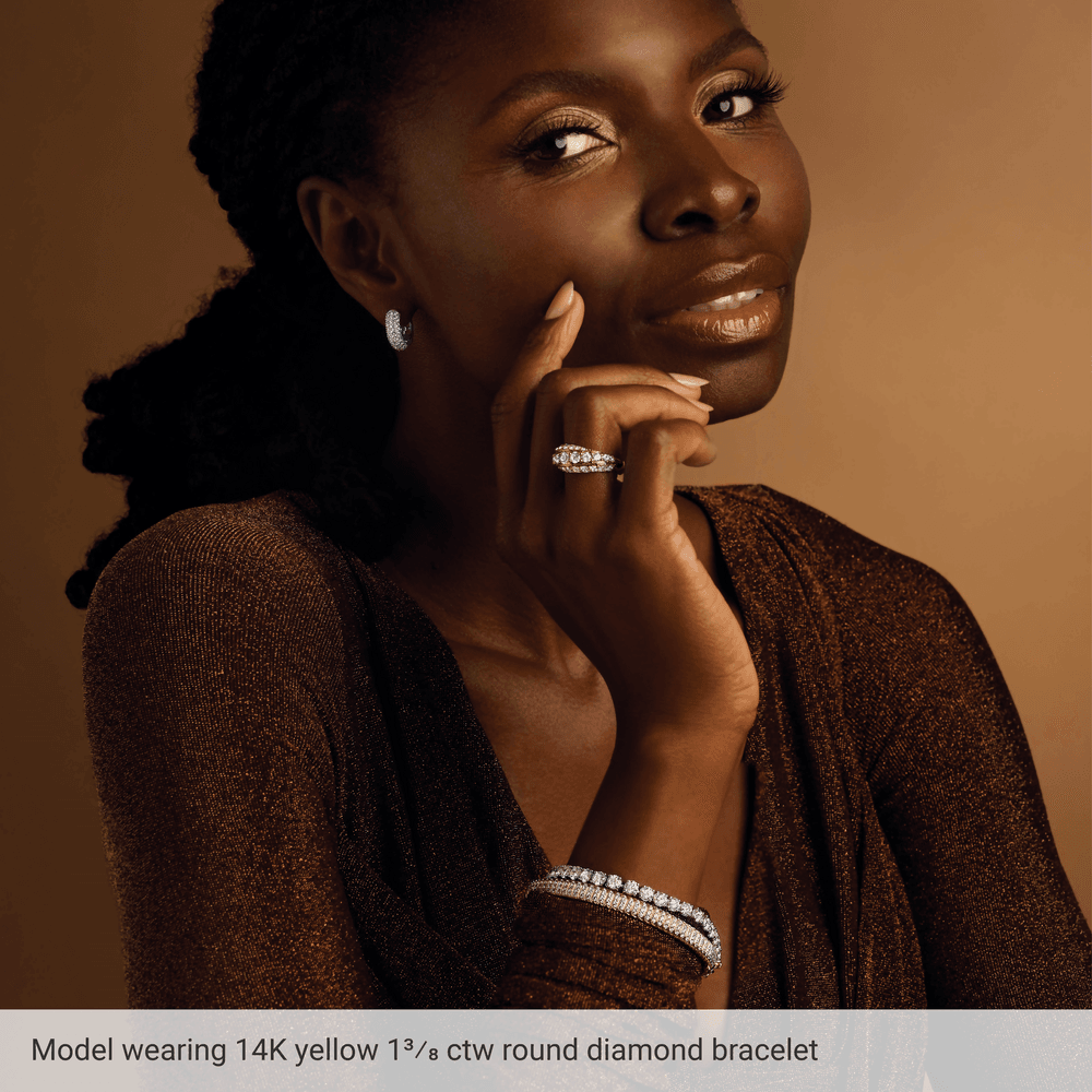 Woman wearing a 14K yellow gold diamond bracelet against a brown background