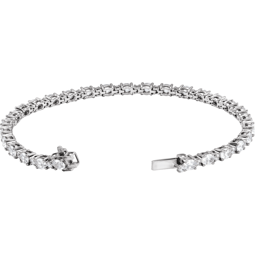 A silver-toned tennis bracelet with a continuous line of round-cut clear stones and a clasp closure, shown on a plain white background.