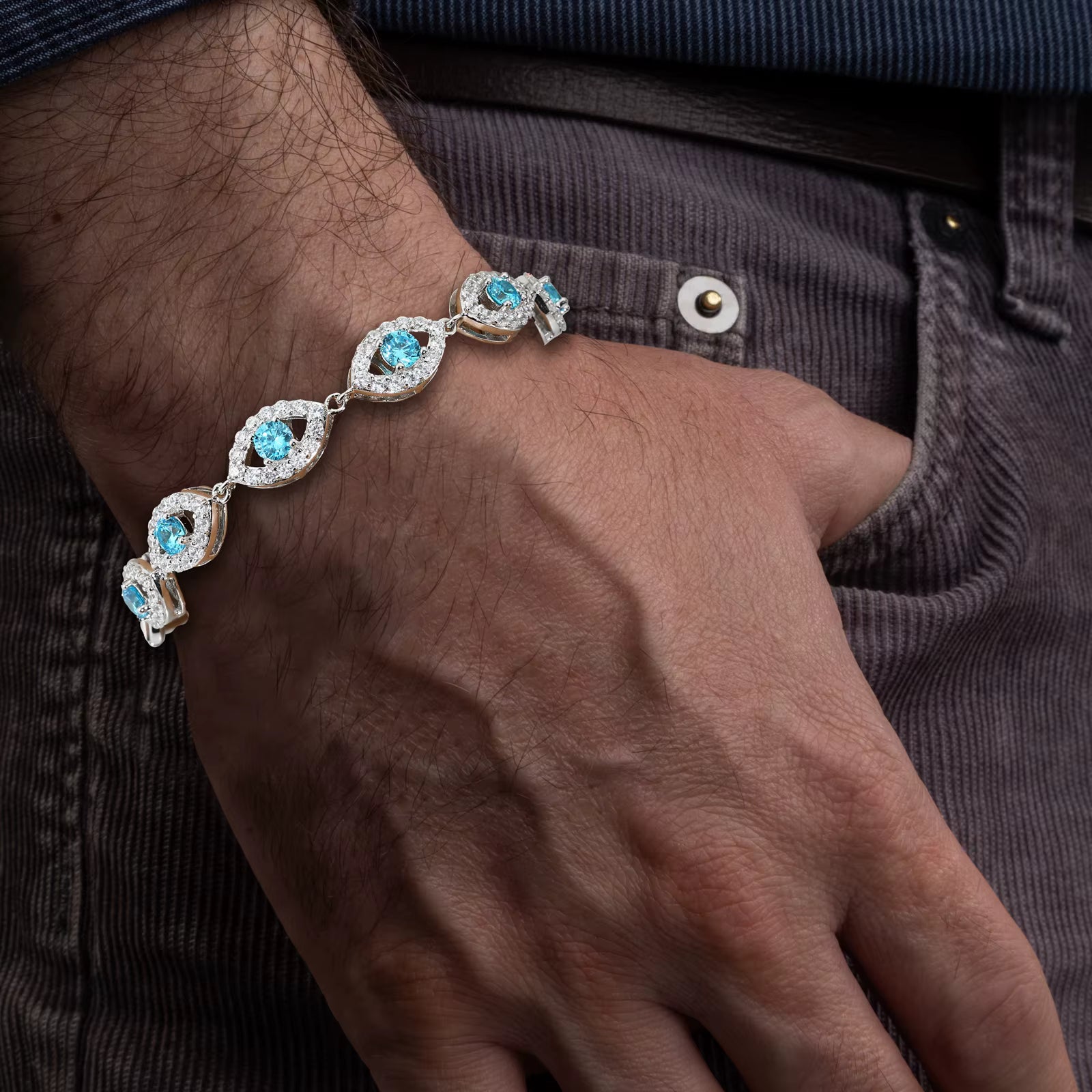 Bracelet with blue gemstones on a wrist against a dark background