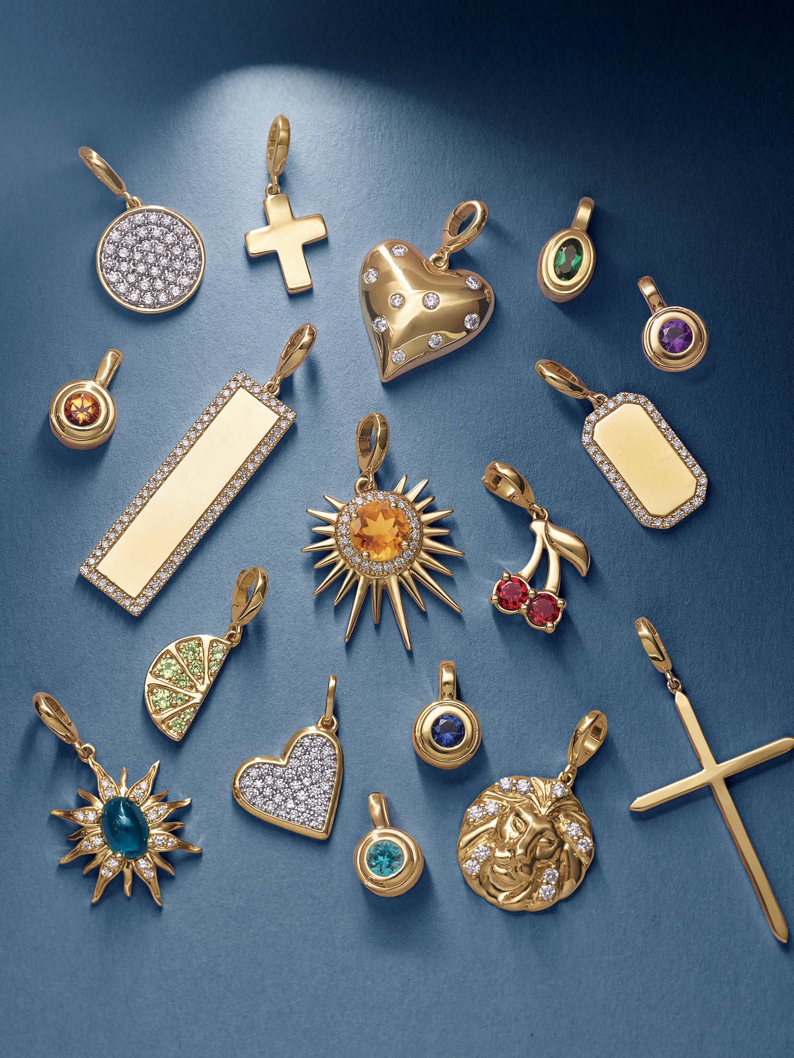 Collection of gold pendants with various designs on a blue background