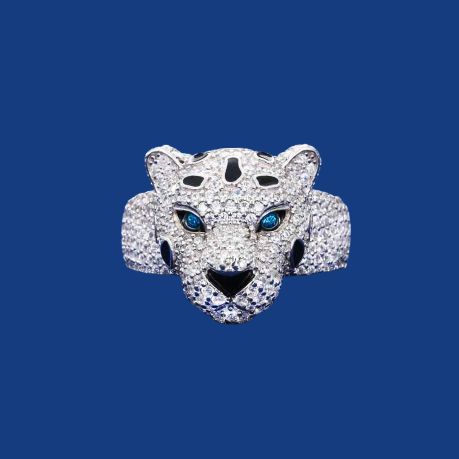 Jewelry ring shaped like a panther head with gemstone eyes on a blue background