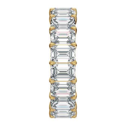 A vertical eternity-style ring featuring a row of baguette-cut clear gemstones set in yellow gold prongs, centered on a plain white background.
