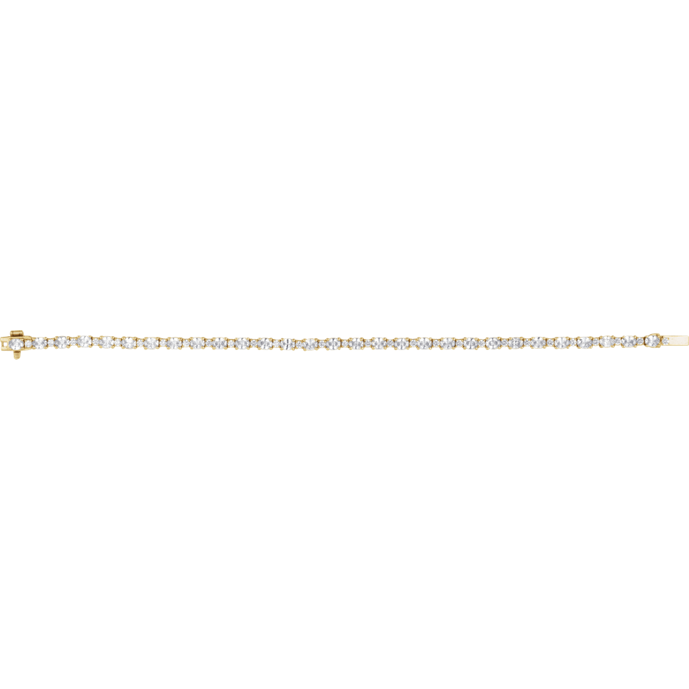 A delicate yellow gold tennis bracelet with a row of small clear round-cut gemstones, shown horizontally against a plain white background.