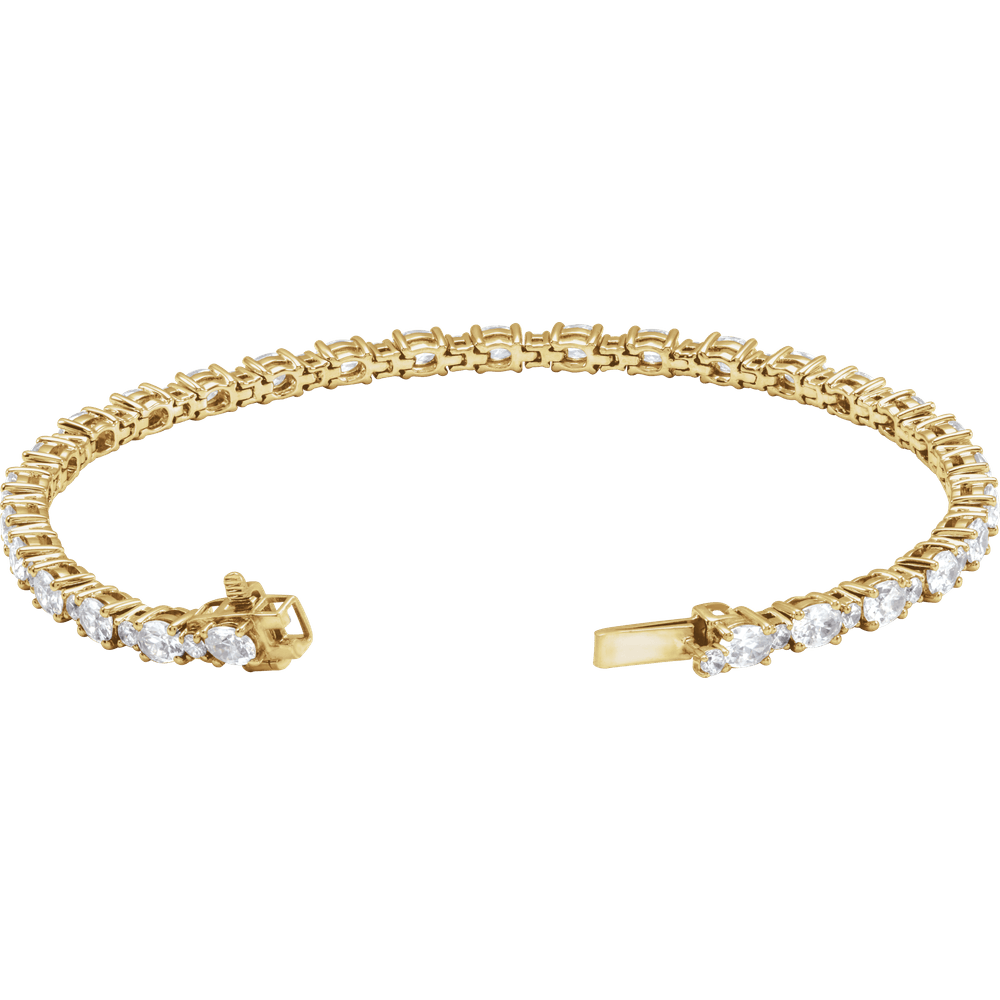 A yellow gold tennis bracelet featuring a continuous row of round-cut clear gemstones along the front, with a clasp closure visible on both ends, set against a plain white background.