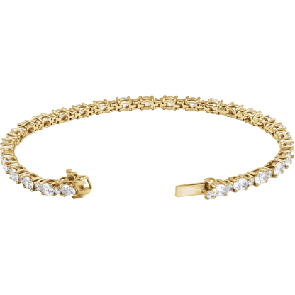 A yellow gold tennis bracelet featuring a continuous row of round-cut clear gemstones along the front, with a clasp closure visible on both ends, set against a plain white background.