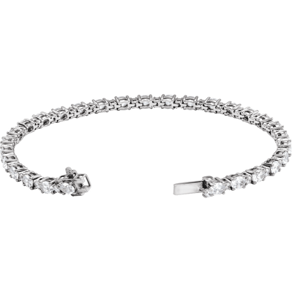 A silver-toned tennis bracelet with a continuous line of round-cut clear stones and a clasp closure, shown on a plain white background.