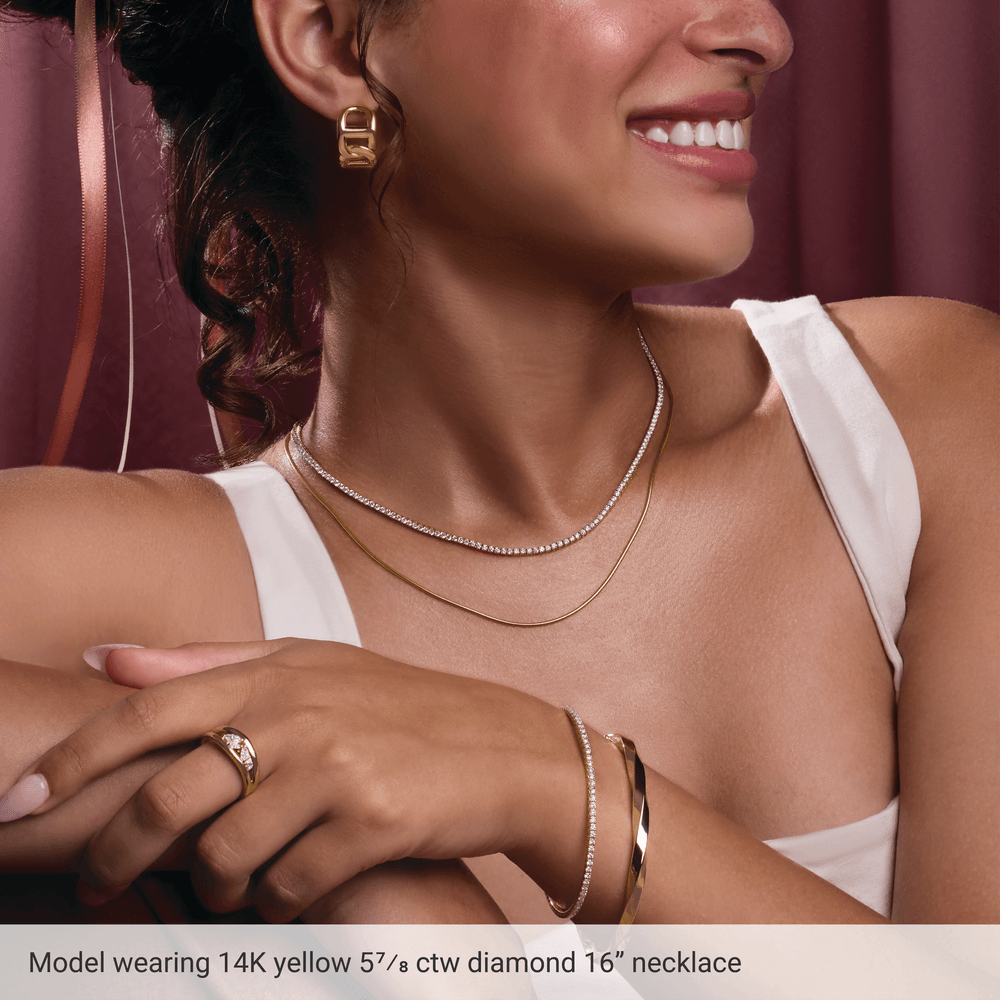Model wearing Guerilla Choice 14K yellow gold diamond necklace with layered gold jewelry
