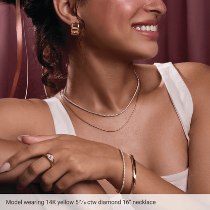 Model wearing Guerilla Choice 14K yellow gold diamond necklace with layered gold jewelry