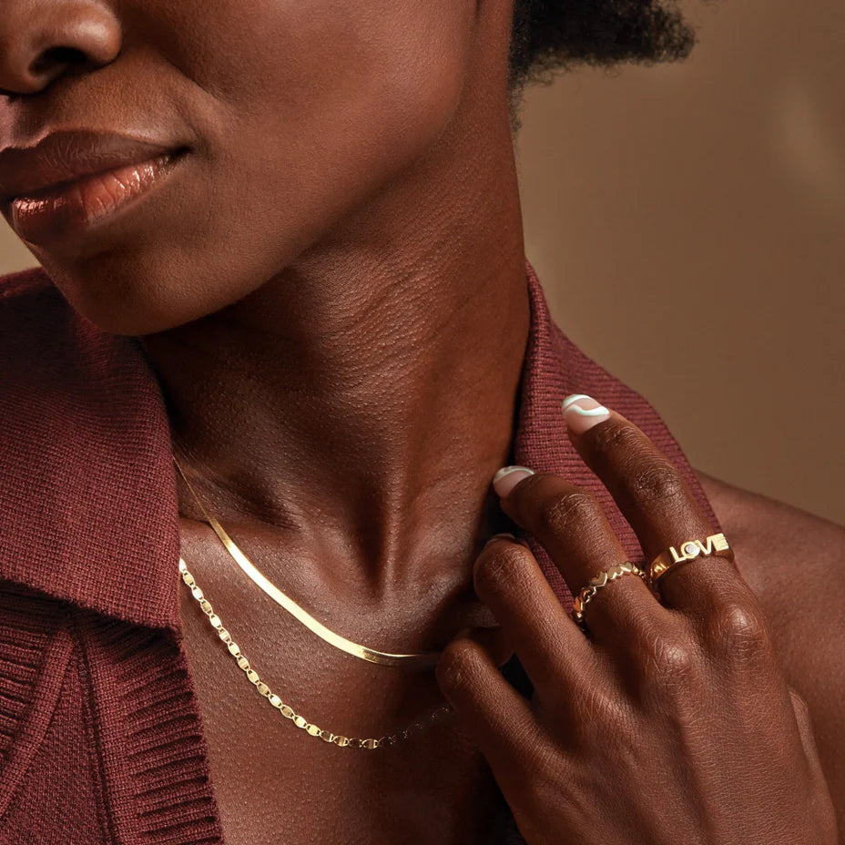 Model wearing Guerilla Choice 14K yellow gold LOVE diamond ring in luxury editorial styling
