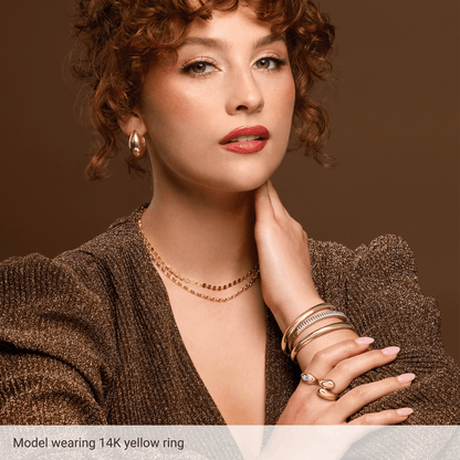 Model wearing Guerilla Choice sculptural gold statement ring with layered gold jewelry