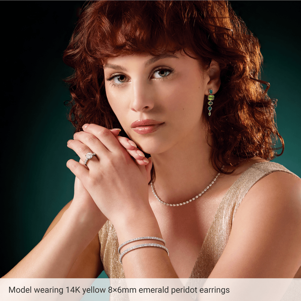 Model wearing Guerilla Choice 14K yellow gold peridot dangle earrings in luxury editorial styling