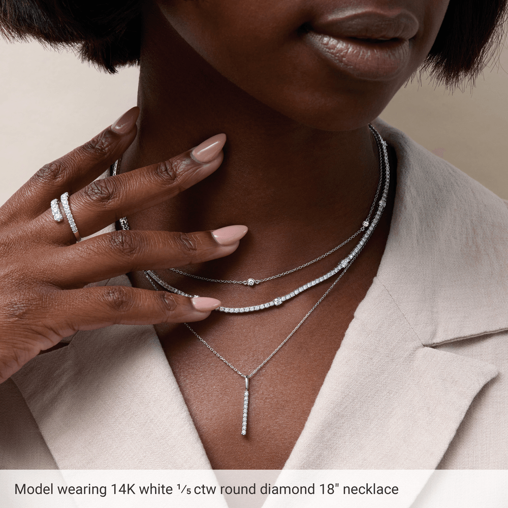 Model wearing Guerilla Choice 14K white gold three stone diamond necklace in luxury editorial styling