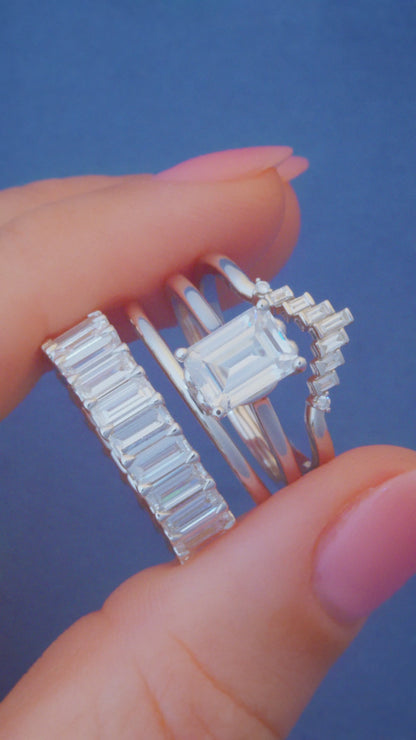 Profile view of a low-profile 14K yellow gold baguette diamond eternity band with four-claw prong settings